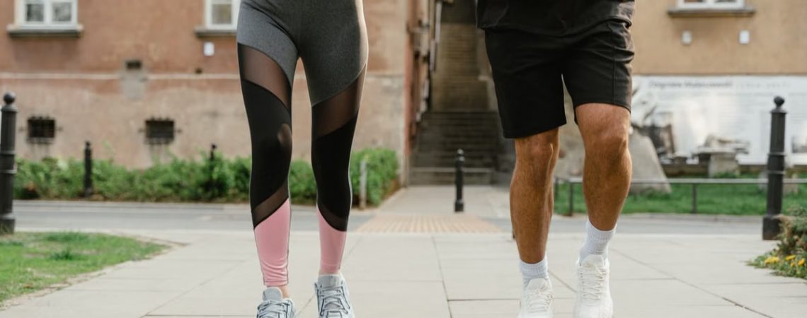 Two adults jogging outdoors, promoting health and fitness in an urban setting.